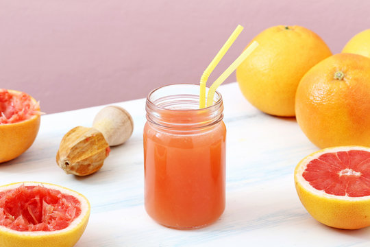 succo di frutta spremuta di pompelmo in barattolo di vetro sfondo colorato