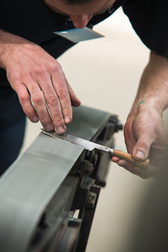 man sharpening his knife on sharpening machine