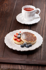 Cottage cheese casserole with berries on wooden background