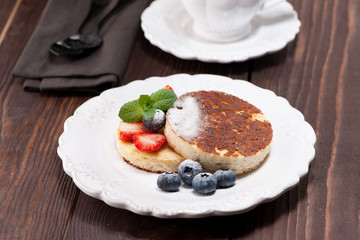 Cottage cheese casserole with berries on wooden background