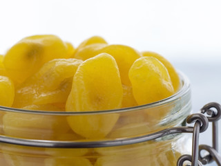 little yellow kumquat in glass jar om wooden table