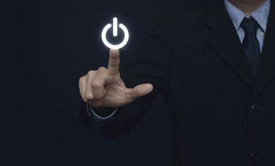 Businessman pressing power button on blue background