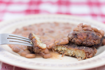 Sliced meatballs on the plate with cooked beans