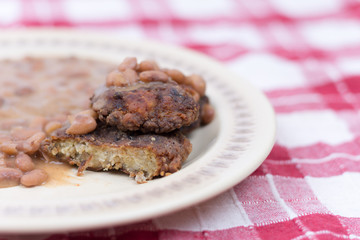 Sliced meatballs on the plate with cooked beans