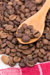 Coffee beans on the wooden spoon macro closeup