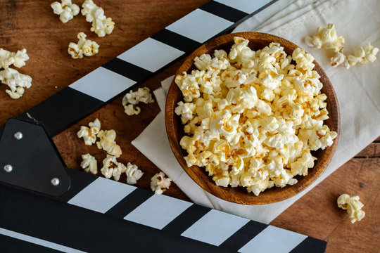 Movie clapper with popcorn on wooden background