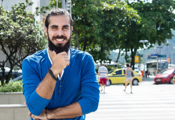 Mann mit Vollbart im blauen Shirt in der Stadt