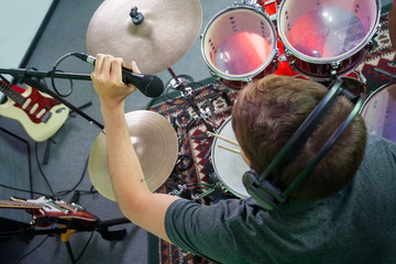 Male Drummer Adjusting Microphone In Recording Studio