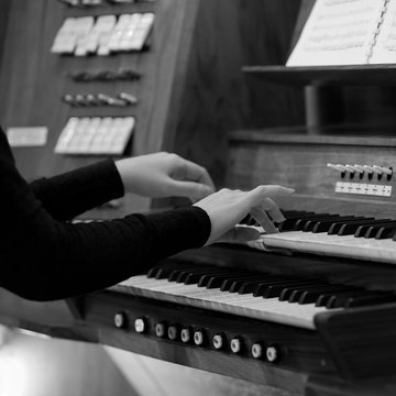 Hands of a woman playing the organ in black and white