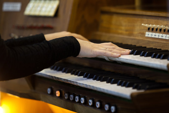 Hands of a woman playing the organ