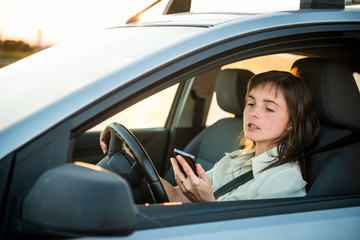 Fototapeta na wymiar Driving car and looking in phone