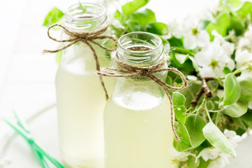 Two bottles of apple cider decorated pear blossom. Selective focus