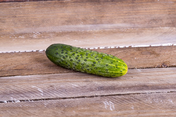 green cucumber on old boards
