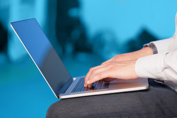 Businessman pressing modern laptop computer on colorful backgrou