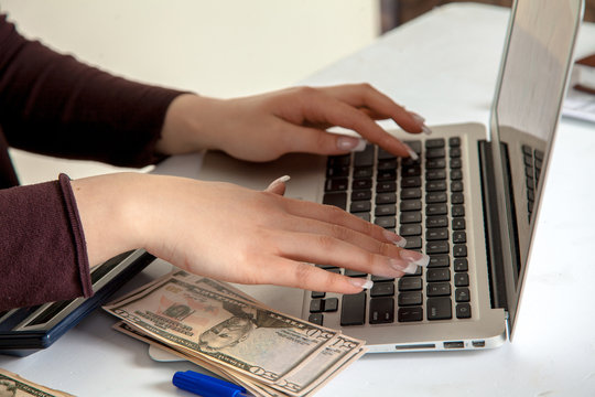 Girl accountant working with money on a laptop