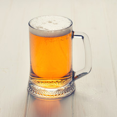 Mug of beer on wooden background