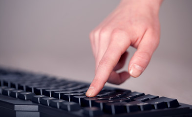Close up of hand pressing keyboard buttons