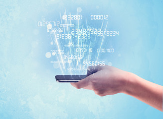 Hand holding phone with digital numbers