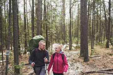 Fototapeta premium Tourists guy and girl goes through the woods