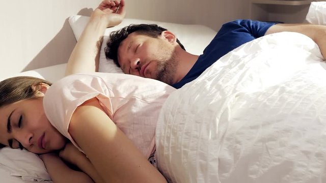 Woman not feeling love for boyfriend sleeping in bed dolly shot 4K