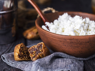 earthenware brown plate with white cottage cheese with dried fruits and nuts for healthy breakfast