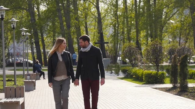 Loving couple walking along park alley