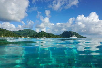 Fototapeta premium Coastal landscape of Huahine island near the village of Fare, seen from calm water surface of the lagoon, Pacific ocean, French Polynesia