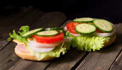 Sandwich with salad and other vegetables on old gray boards