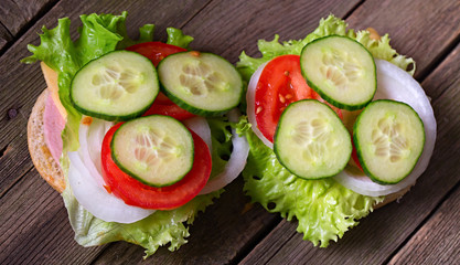 Sandwich with salad and other vegetables on old gray boards