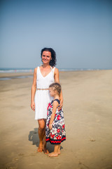 Happy family. Young beautiful mother and her daughter having fun on the beach. Positive human emotions, feelings. 