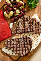 Club Beef steak with pepper sauce and Grilled vegetables on cutting board on wooden background