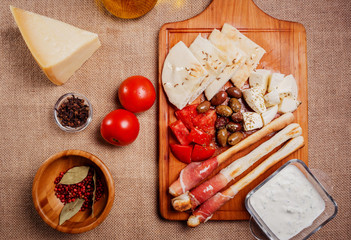 Bread sticks with prosciutto Cured Meat on a wooden cutting boar