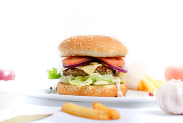 Burger topped with vegetables, spices and fries