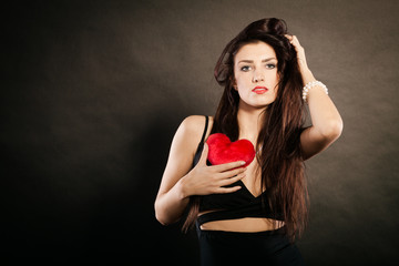 Beautiful woman holds red heart on black