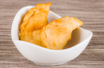 Closeup delicious empanadas lying in a small white bowl