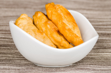 Closeup delicious empanadas lying in a small white bowl
