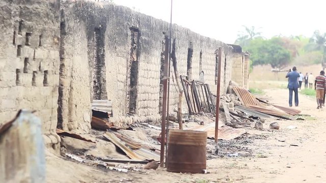 People walk away from a Burnt Down Building at Agatu, Benue Stae Nigeria