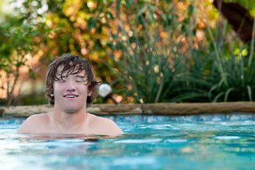 Happy teen in swimming pool with copy space.