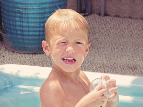 Wet Little Boy Squinting In The Sun