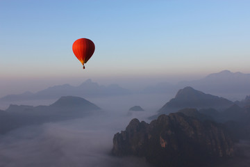 Red Hot-air Balloon float over Misty Mountain in Vang Vieng, Lao