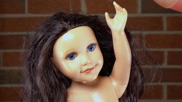 Child's baby doll with gasoline being poured on head prior to igniting.
