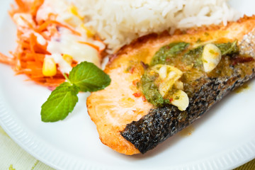 Rice and salmon steak with spicy sauce.