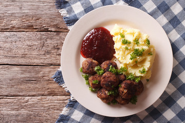 fried meatballs, lingonberry sauce with potato garnish. Horizontal top view
