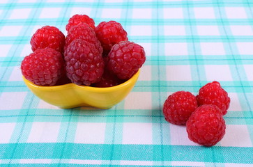 Fresh raspberries on checkered tablecloth, healthy food
