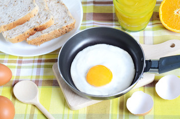Fried egg, toast bread, fresh juice and oranges