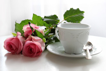 Obraz na płótnie Canvas Elegant antique tea cup and pink roses