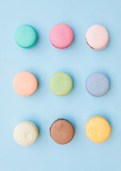 Obraz na płótnie Canvas Sweet colorful French macaroon biscuits on pastel blue background