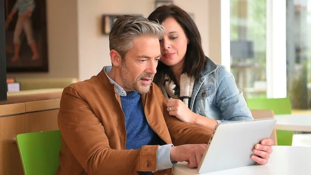 Mature couple in coffee shop connected on internet