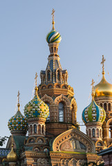 Fototapeta na wymiar View of the domes and the bell tower, the 19th century Church of the Savior on blood in St. Petersburg, on the background of blue sky. Summer 2015.