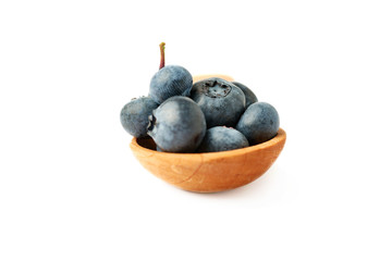Wooden spoon filled of Bilberry or blueberry over isolated white background